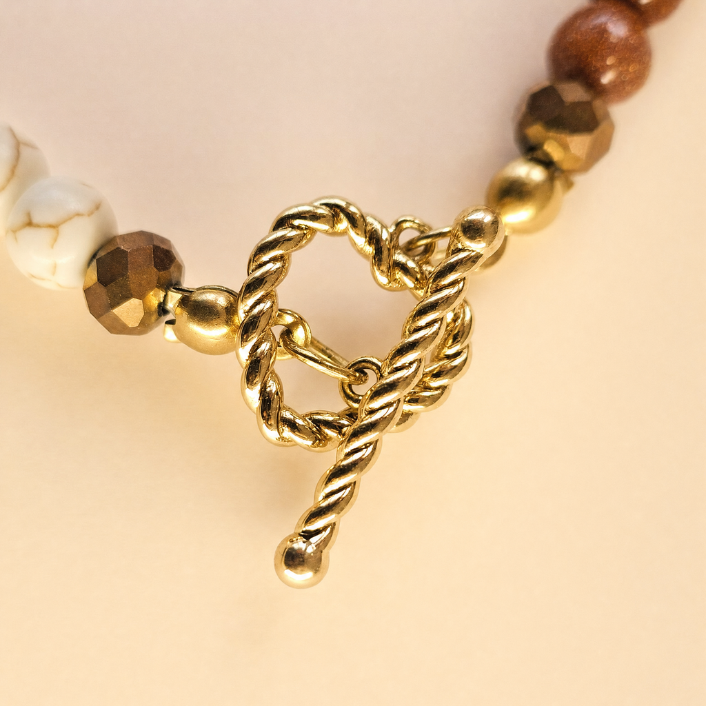 Zbliżenie na złote zapięcie toggle naszyjnika z howlitu i goldstone